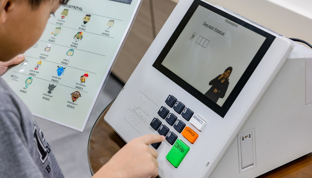 uma criança votando em personagens fictícios na urna eletrônica 