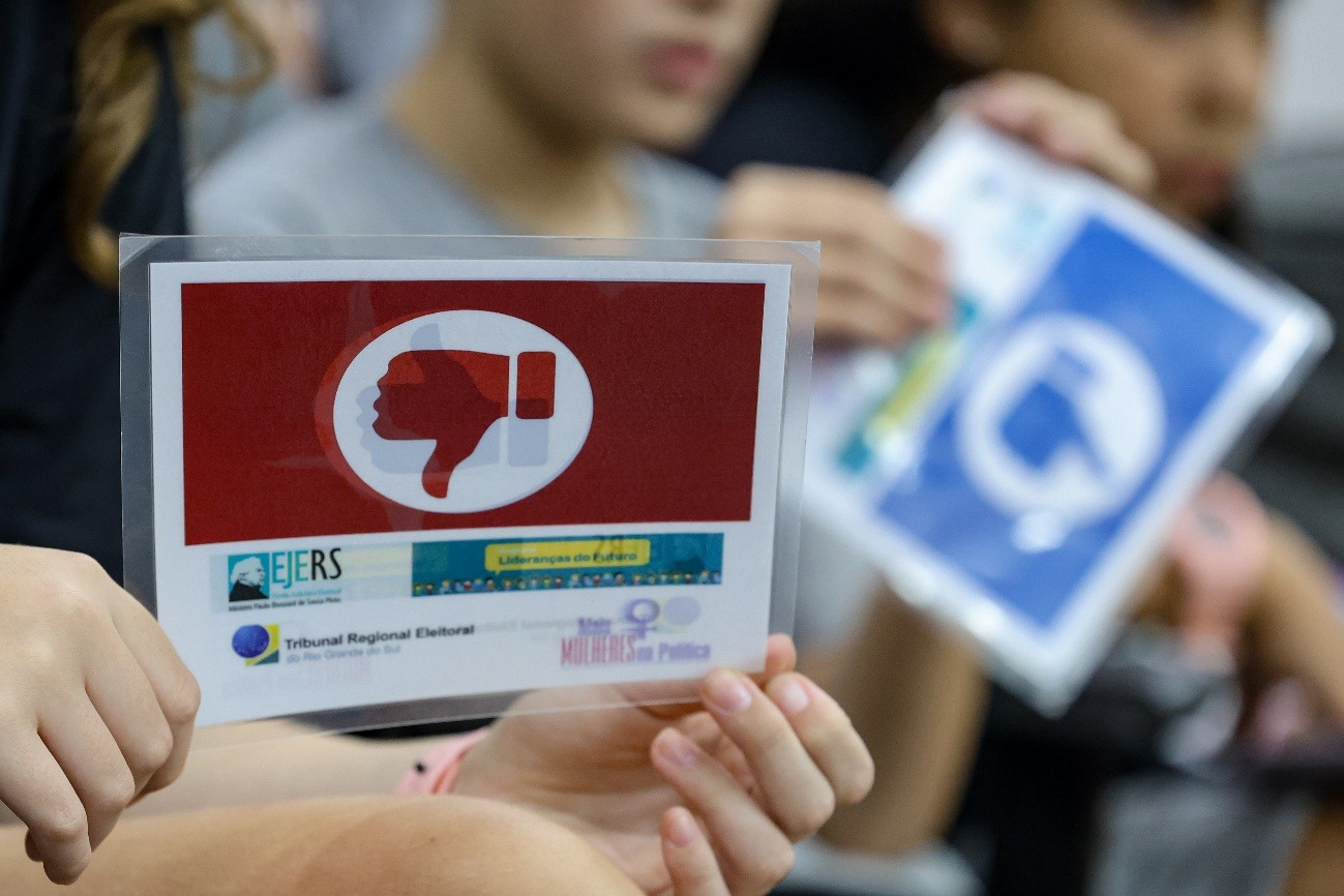 uma placa de "sim" e uma placa de "não" na mão de duas crianças difeentes.