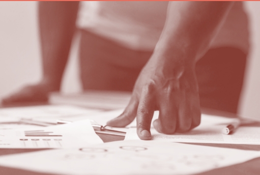 Uma mão apontando para uma folha com dados escritos nela.